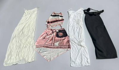 three dresses and a hat are laid out on a table