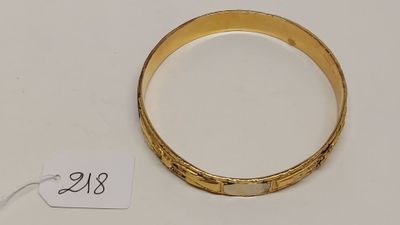 Gros plan sur un bracelet en or portant une étiquette