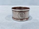 a close up of a silver ring with a monogram on it