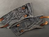 two pairs of grey canvas and leather gloves on a gray surface