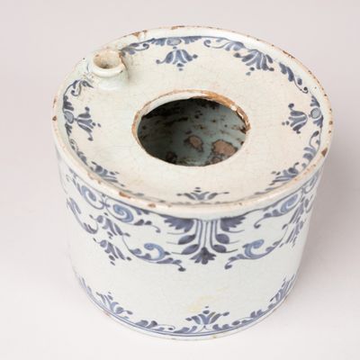 a white and blue vase with a hole in it