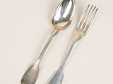 deux cuillères et une fourchette en argent sur une table