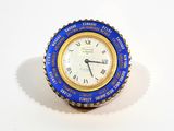 a blue and gold clock with roman numerals on it