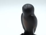 an image of a black owl figurine sitting on top of a black base
