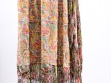 a multicolored scarf hanging on a hanger against a white wall