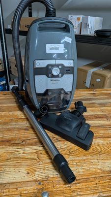 un aspirateur posé sur une table en bois