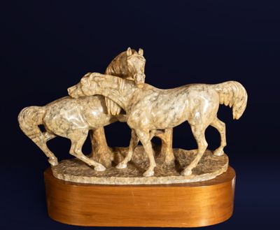 une statue représentant un groupe de chevaux, posée sur un socle en bois