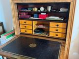 a wooden desk with a black top and drawers