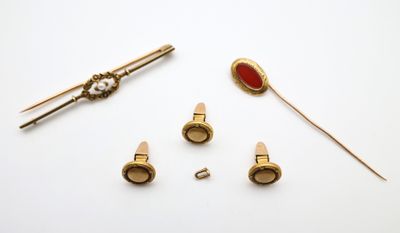 une image représentant un ensemble d'objets dorés et rouges posés sur une surface blanche