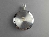 a small silver pocket watch on a gray surface