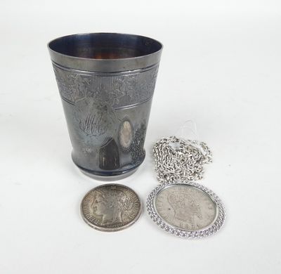 une coupe en argent entourée d'une chaîne, avec une pièce à côté