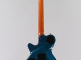 an electric guitar hanging from a string on a white wall