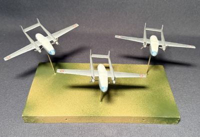 trois maquettes d'avions posées sur un socle en bois