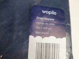 une étiquette au dos d'un t-shirt sur laquelle est inscrit « woppilo »