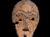 un gros plan d'un masque en argile sur fond noir
