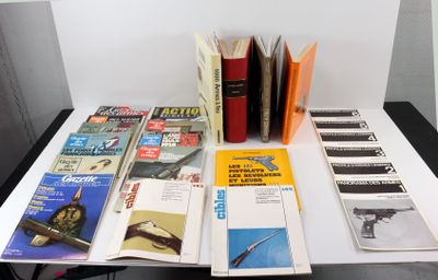 beaucoup de livres posés sur une table sur laquelle se trouve un pistolet