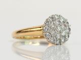an image of a diamond cluster ring on a reflective surface