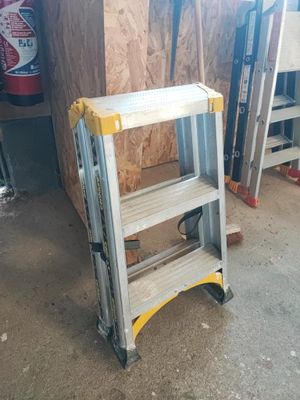 une échelle posée dans un garage, contre un mur
