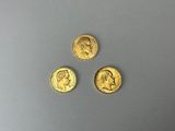 trois pièces d'or portant l'image d'un homme et d'une femme