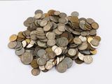 une pile de pièces de monnaie posée sur une table blanche