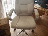 une chaise de bureau blanche placée devant une fenêtre
