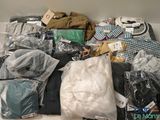 a lot of clothes that are sitting on top of a table