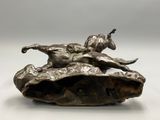 bronze sculpture of a man laying on a shell with a dog