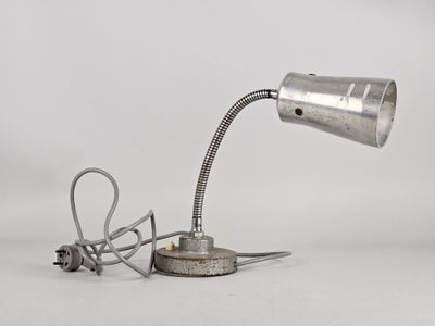 a silver lamp with a cord attached to it on a white surface
