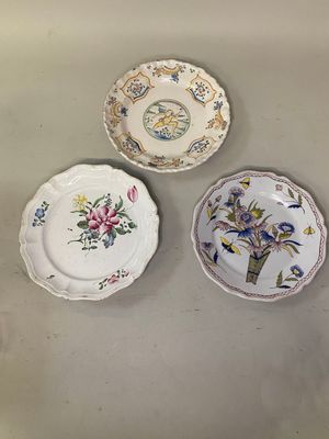 trois assiettes ornées de motifs floraux sont posées sur une table
