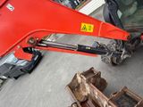an image of a red excavator parked in a lot