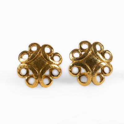 a pair of gold toned earrings with a circular design