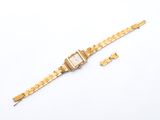 a close up of a gold watch on a white surface