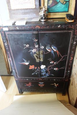une armoire noire décorée de fleurs et d'oiseaux peints