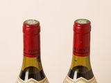 two bottles of wine sitting next to each other on a table