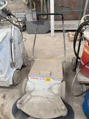 a machine that is sitting on the ground next to a bucket