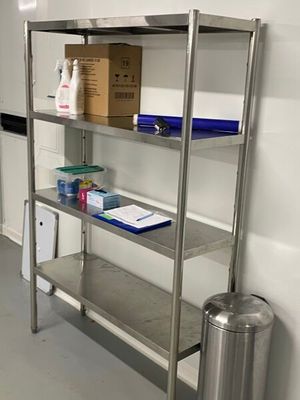 a metal shelving with a bin and a trash can