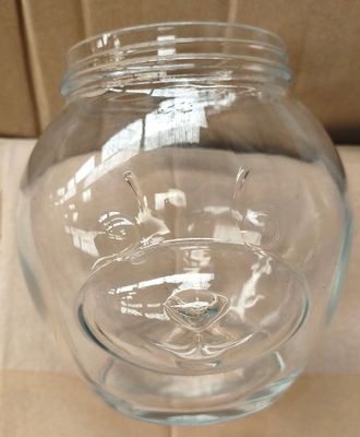 un bocal en verre contenant un visage, posé sur une table