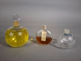 three bottles of perfume sitting next to each other on a table
