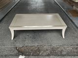 a white coffee table sitting in the middle of a parking lot
