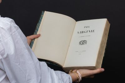 someone is holding a book in their hands with a black background