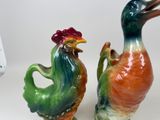 two ceramic birds that are standing next to each other