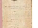 un vieux livre posé sur une table à côté d'un mur blanc