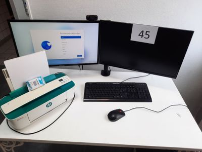 a computer desk with two monitors and a keyboard on it