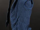 a blue denim vest on a mannequin stand against a black background