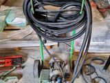 un tuyau vert et noir posé sur un chariot dans un garage