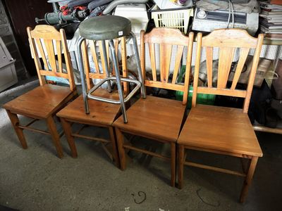 four wooden chairs sitting next to each other in a room