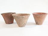 trois tasses posées les unes à côté des autres sur une surface blanche