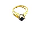 a close up of a gold ring with a black stone