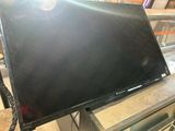 La télévision à écran plat est posée sur un support métallique.