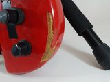 a red vacuum with a black handle on a white surface